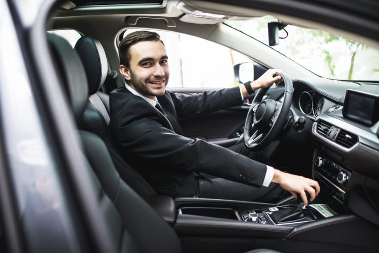 Chofer ejecutivo de traje al volante, listo para un traslado en la Triple Frontera